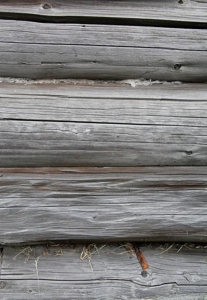 De muur van de oude houten balken in de scheuren en takken. — Stockfoto