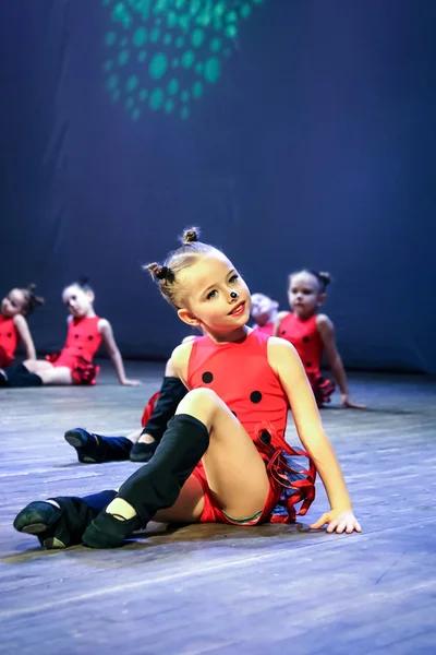 ダンスレディバード - 赤いスーツと笑顔でステージに座っている女の子 — ストック写真