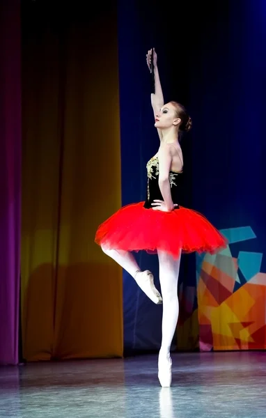 Μπαλέτο-μια μπαλαρίνα σε ένα κόκκινο χέρι με φούστα και ένα πόδι πάνω. — Φωτογραφία Αρχείου
