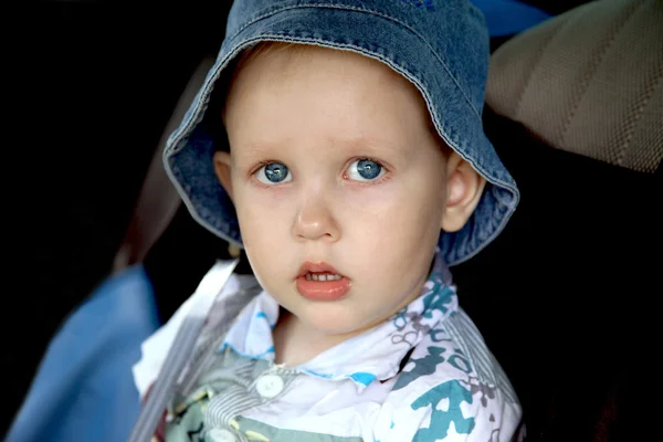 Blue-eyed boy on the back seat of car — Stock Photo, Image