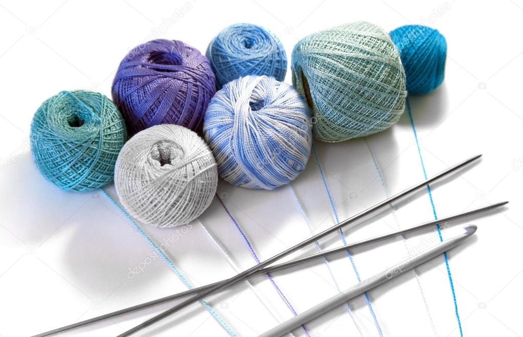 Colored thread for knitting needles and crochet, hook on a white background