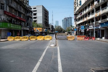 MUMBAI / INDIA - APRIL 7, 2020: COVID-19 Coronavirus 'un yayılmasına karşı önleyici bir önlem olarak hükümet tarafından ülke çapında tecrit edilen Worli, BDD Chwal' da önleme alanına giden yolu engelleyen engeller.