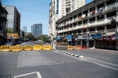 MUMBAI / INDIA - APRIL 7, 2020: COVID-19 Coronavirus 'un yayılmasına karşı önleyici bir önlem olarak hükümet tarafından ülke çapında tecrit edilen Worli, BDD Chwal' da önleme alanına giden yolu engelleyen engeller.