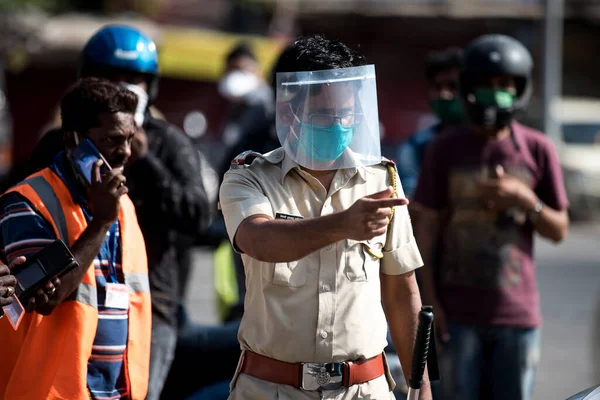 MUMBAI/INDIA - APRIL 7, 2020: Police wears protective masks stand guard at a checkpoint in Dharavi during a nationwide lockdown as a preventive measure against the spread of the COVID-19 coronavirus.