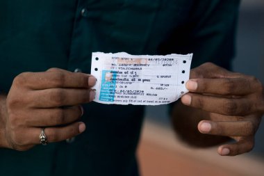 MUMBAI / INDIA - 8 Mayıs 2020: Göçmen işçiler, ülke çapındaki tecrit sırasında doğal yerlerini geri almak üzere trene binmek üzere LTT terminaline vardıklarında tren biletlerini sergiliyorlar.