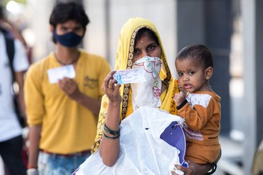 MUMBAI / INDIA - 8 Mayıs 2020: Göçmen işçiler, ülke çapındaki tecrit sırasında doğal yerlerini geri almak üzere trene binmek üzere LTT terminaline vardıklarında tren biletlerini sergiliyorlar.