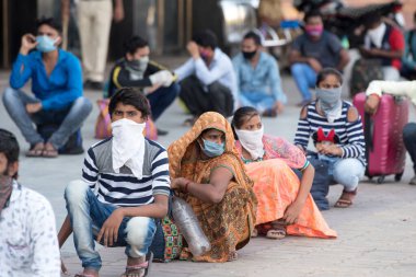 MUMBAI / INDIA - 8 Mayıs 2020: Göçmen işçiler, bir LTT terminaline girmek ve ülke çapındaki tecrit sırasında yerli yerlerini geri almak için trene binmek için kuyruğa girdiler