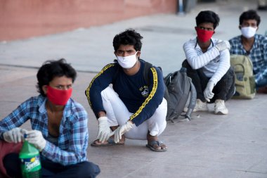 MUMBAI / INDIA - 8 Mayıs 2020: Göçmen işçiler, bir LTT terminaline girmek ve ülke çapındaki tecrit sırasında yerli yerlerini geri almak için trene binmek için kuyruğa girdiler