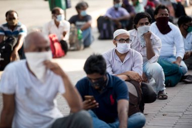 MUMBAI / INDIA - 8 Mayıs 2020: Göçmen işçiler, bir LTT terminaline girmek ve ülke çapındaki tecrit sırasında yerli yerlerini geri almak için trene binmek için kuyruğa girdiler