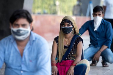 MUMBAI / INDIA - 8 Mayıs 2020: Göçmen işçiler, bir LTT terminaline girmek ve ülke çapındaki tecrit sırasında yerli yerlerini geri almak için trene binmek için kuyruğa girdiler