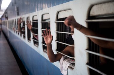 MUMBAI / INDIA - 8 Mayıs 2020: Göçmen işçiler, LTT Terminali 'ndeki evlerine dönüş yolculukları için bir tren dalgalarının içinde oturuyorlar.