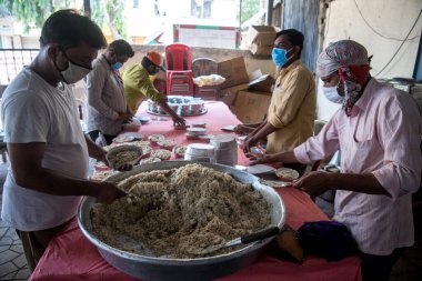 MUMBAI / INDIA - APRIL 24, 2020: Koronavirüse karşı önleyici bir önlem olarak, ülke çapındaki tecrit sırasında Kurla 'daki ihtiyaç sahipleri arasında yiyecek paketleri hazırlayan gönüllü.