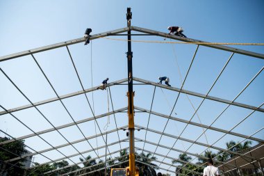 MUMBAI/INDIA - APRIL 28, 2020: Workers sets up scaffolding at a construction of new isolation centre at Dharavi as a preventive measure against the COVID-19 coronavirus.