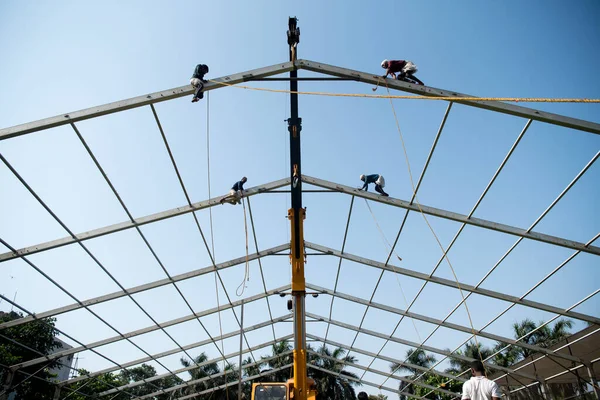 MUMBAI/INDIA - APRIL 28, 2020: Workers sets up scaffolding at a construction of new isolation centre at Dharavi as a preventive measure against the COVID-19 coronavirus.