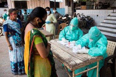 MUMBAI / INDIA-APRIL 29, 2020: Coronavirus 'un yayılmasına karşı önleyici bir önlem olarak bir tıp çalışanı, Dadar' daki COVID-19 Coronavirus test sürüşüne katılıyor