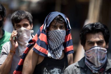 MUMBAI / INDIA - 2 Mayıs 2020: Göçmen işçiler COVID-19 Coronavirus 'a karşı önleyici bir önlem olarak ülke çapındaki tecrit sırasında Dharavi gecekondu mahallesindeki evlerine geri dönmek için kayıt formu almak üzere kuyruğa girdiler.