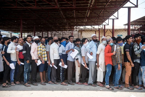 MUMBAI / INDIA - 6 Mayıs 2020: Göçmen işçiler COVID-19 Coronavirus 'a karşı önleyici bir önlem olarak ülke çapındaki tecrit süresince evlerine geri dönebilmek için doktor sertifikaları almak için kuyrukta bekliyorlar