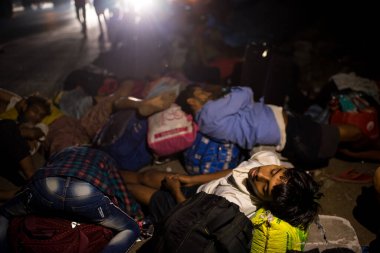 MUMBAI / INDIA - 9 Mayıs 2020: Göçmen işçiler, Coronavirus 'un yayılmasına karşı önleyici bir önlem olarak ülke çapındaki tecrit süresince Thane Bhiwandi karayolunda uyur..