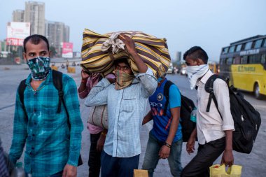 MUMBAI / INDIA - 9 Mayıs 2020: Göçmen işçiler, koronavirüsün yayılmasına karşı önleyici bir önlem olarak Bhiwandi karayolunda yurda dönüş yolculuklarında yürüyorlar.
