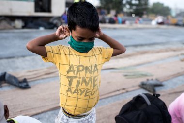 MUMBAI / INDIA - 9 Mayıs 2020: Coronavirus 'un yayılmasına karşı önleyici bir önlem olarak Bhiwandi otobanındaki yolculuklarında maske takarak ailesiyle birlikte oturuyorlar..