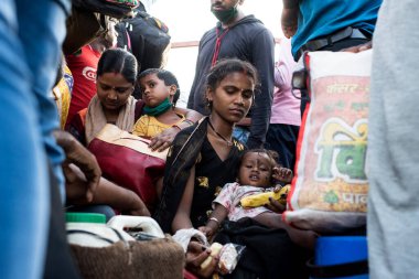 MUMBAI / INDIA - 9 Mayıs 2020: Göçmen işçiler, koronavirüsün yayılmasına karşı önleyici bir önlem olarak Bhiwandi karayolu üzerindeki evlerine dönüş yolculuklarında bavullarıyla bir kamyonet ile seyahat ediyorlar.