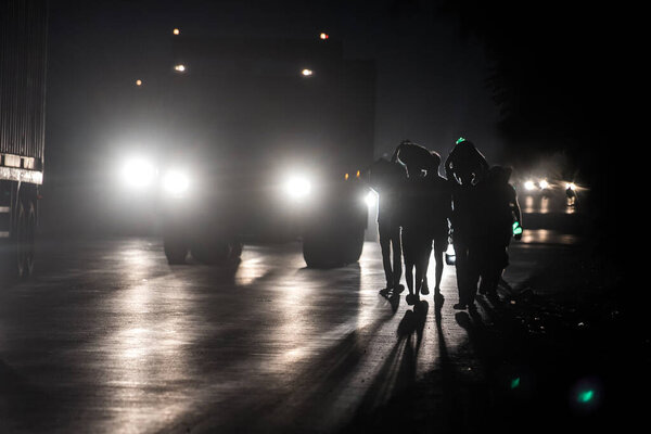 МУМБАЙ / ИНДИЯ - 9 мая 2020 года: Трудящиеся-мигранты ходят ночью по шоссе Тане Бхиванди по пути домой во время общенациональной изоляции в качестве профилактической меры против распространения коронавируса.