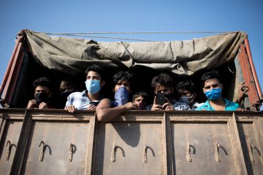 MUMBAI / INDIA - 11 Mayıs 2020: Göçmen işçiler, koronavirüsün yayılmasına karşı önleyici bir önlem olarak Bhiwandi otobanına dönüş yolculuklarında tempoda seyahat ediyorlar.