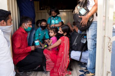 MUMBAI / INDIA - 11 Mayıs 2020: Göçmen işçiler koronavirüsün yayılmasına karşı önleyici bir önlem olarak Bhiwandi otobanına dönüş yolculuklarında bavullarıyla birlikte tempoda seyahat ediyorlar.