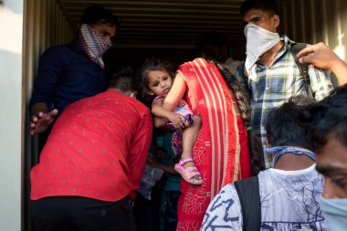 MUMBAI / INDIA - 11 Mayıs 2020: Göçmen işçiler, koronavirüsün yayılmasına karşı önleyici bir önlem olarak Bhiwandi otobanındaki eve dönüş yolculuklarında bavullarıyla tempo tutturdular.