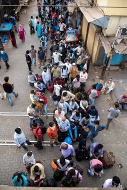MUMBAI / INDIA - 13 Mayıs 2020: Göçmen işçiler, koronavirüsün yayılmasına karşı önleyici bir önlem olarak Bandra 'daki eve dönüş trenine bindikleri için tren terminalinin önünde kuyruğa girdiler