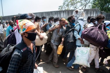 MUMBAI / INDIA - 14 Mayıs 2020: Göçmen işçiler, Coronavirus 'un yayılmasına karşı önleyici bir önlem olarak, yurt çapındaki tecrit sırasında evlerine dönüş yolculuklarında özel trene binmeye çalışıyorlar.