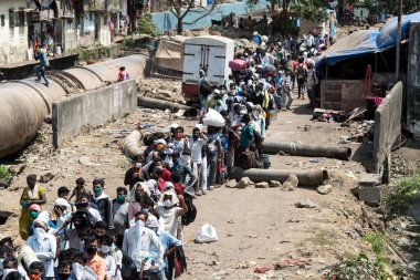MUMBAI / INDIA - 14 Mayıs 2020: Göçmen işçiler, Coronavirus 'un yayılmasına karşı önleyici bir önlem olarak yurda dönüş yolculuklarında özel bir trene bindikleri için Bandra tren istasyonuna vardılar.