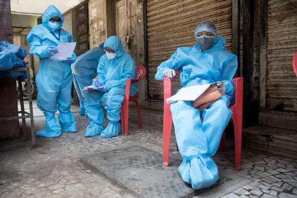 MUMBAI / INDIA - 14 Mayıs 2020: Coronavirus 'un yayılmasına karşı önleyici bir önlem olarak Dharavi gecekondu mahallesindeki COVID-19 Coronavirus test sürüşünde hastaları bekleyen tıp çalışanı.