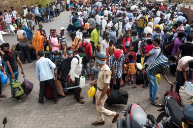 MUMBAI / INDIA - 16 Mayıs 2020: Lokmanya Tilak tren istasyonunun dışındaki göçmen işçi kalabalığı, koronavirüsün yayılmasına karşı önleyici bir önlem olarak ülke çapındaki tecrit sırasında kendi yerlerini almak üzere özel bir trene bindikleri için eksi.