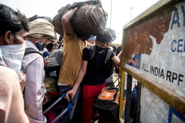 MUMBAI / INDIA - 16 Mayıs 2020: Lokmanya Tilak tren istasyonunun dışındaki göçmen işçi kalabalığı, koronavirüsün yayılmasına karşı önleyici bir önlem olarak ülke çapındaki tecrit sırasında kendi yerlerini almak üzere özel bir trene bindikleri için eksi.