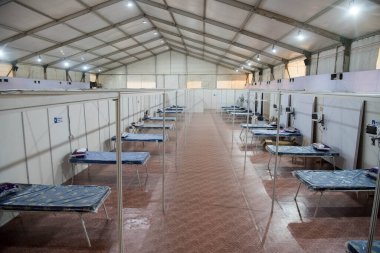 MUMBAI / INDIA - 18 Mayıs 2020: COVID-19 Coronavirus 'a karşı önleyici tedbir olarak ülke çapındaki tecrit sırasında Bandra Kurla Kompleksi' nin yeni inşa edilen Covid-19 izolasyon merkezine yatak sıraları yerleştirilir.