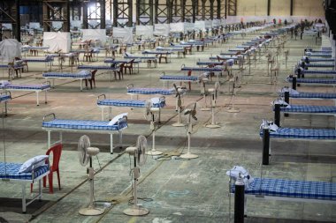 MUMBAI / INDIA - 19 Mayıs 2020: COVID-19 Coronavirus 'a karşı önleyici bir önlem olarak ülke çapındaki tecrit sırasında NESCO' daki yeni inşa edilen Covid-19 izolasyon merkezine yatak sıraları yerleştirilir