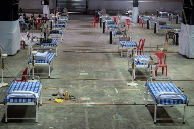 MUMBAI / INDIA - 19 Mayıs 2020: COVID-19 Coronavirus 'a karşı önleyici bir önlem olarak ülke çapındaki tecrit sırasında NESCO' daki yeni inşa edilen Covid-19 izolasyon merkezine yatak sıraları yerleştirilir