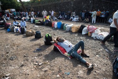 MUMBAI / INDIA - 20 Mayıs 2020: Göçmen işçiler Chhatrapati Shivaji Maharaj Terminus yakınlarındaki kuyruğa bavullarını bırakırlar.