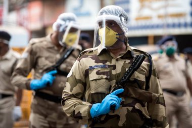 MUMBAI / INDIA - 20 Mayıs 2020: Merkezi Endüstriyel Güvenlik Gücü (CISF), koronavirüsün yayılmasına karşı önleyici bir önlem olarak, Bhendi Çarşısı sokaklarında devriye için maske takıyor.