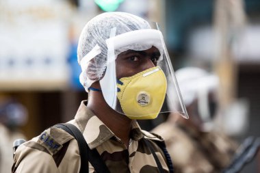 MUMBAI / INDIA - 20 Mayıs 2020: Merkezi Endüstriyel Güvenlik Gücü (CISF), koronavirüsün yayılmasına karşı önleyici bir önlem olarak, Bhendi Çarşısı sokaklarında devriye için maske takıyor.