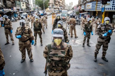 MUMBAI / INDIA - 20 Mayıs 2020: Merkezi Endüstriyel Güvenlik Gücü (CISF), koronavirüsün yayılmasına karşı önleyici bir önlem olarak, Bhendi Çarşısı sokaklarında devriye için maske takıyor.