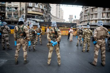MUMBAI / INDIA - 20 Mayıs 2020: Merkezi Endüstriyel Güvenlik Gücü (CISF), koronavirüsün yayılmasına karşı önleyici bir önlem olarak, Bhendi Çarşısı sokaklarında devriye için maske takıyor.