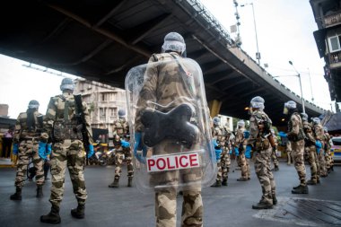 MUMBAI / INDIA - 20 Mayıs 2020: Merkezi Endüstriyel Güvenlik Gücü (CISF), koronavirüsün yayılmasına karşı önleyici bir önlem olarak, Bhendi Çarşısı sokaklarında devriye için maske takıyor.