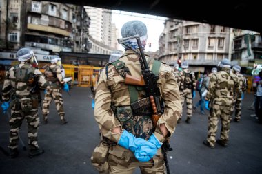 MUMBAI / INDIA - 20 Mayıs 2020: Merkezi Endüstriyel Güvenlik Gücü (CISF), koronavirüsün yayılmasına karşı önleyici bir önlem olarak, Bhendi Çarşısı sokaklarında devriye için maske takıyor.