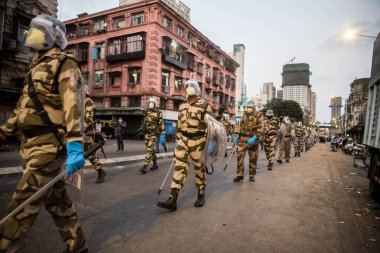 MUMBAI / INDIA - 20 Mayıs 2020: Merkezi Endüstriyel Güvenlik Gücü (CISF), koronavirüsün yayılmasına karşı önleyici bir önlem olarak Bhendi Çarşısı sokaklarında maske takıyor.