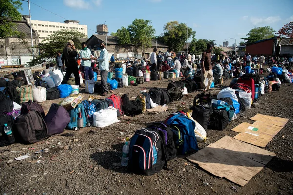MUMBAI / INDIA - 20 Mayıs 2020: Göçmen işçiler Chhatrapati Shivaji Maharaj Terminus yakınlarındaki kuyruğa bavullarını bırakırlar.