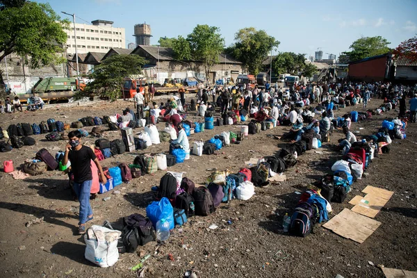 MUMBAI / INDIA - 20 Mayıs 2020: Göçmen işçiler Chhatrapati Shivaji Maharaj Terminus yakınlarındaki kuyruğa bavullarını bırakırlar.