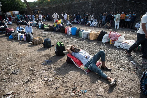 MUMBAI / INDIA - 20 Mayıs 2020: Göçmen işçiler Chhatrapati Shivaji Maharaj Terminus yakınlarındaki kuyruğa bavullarını bırakırlar.
