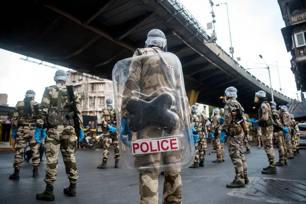 MUMBAI / INDIA - 20 Mayıs 2020: Merkezi Endüstriyel Güvenlik Gücü (CISF), koronavirüsün yayılmasına karşı önleyici bir önlem olarak, Bhendi Çarşısı sokaklarında devriye için maske takıyor.